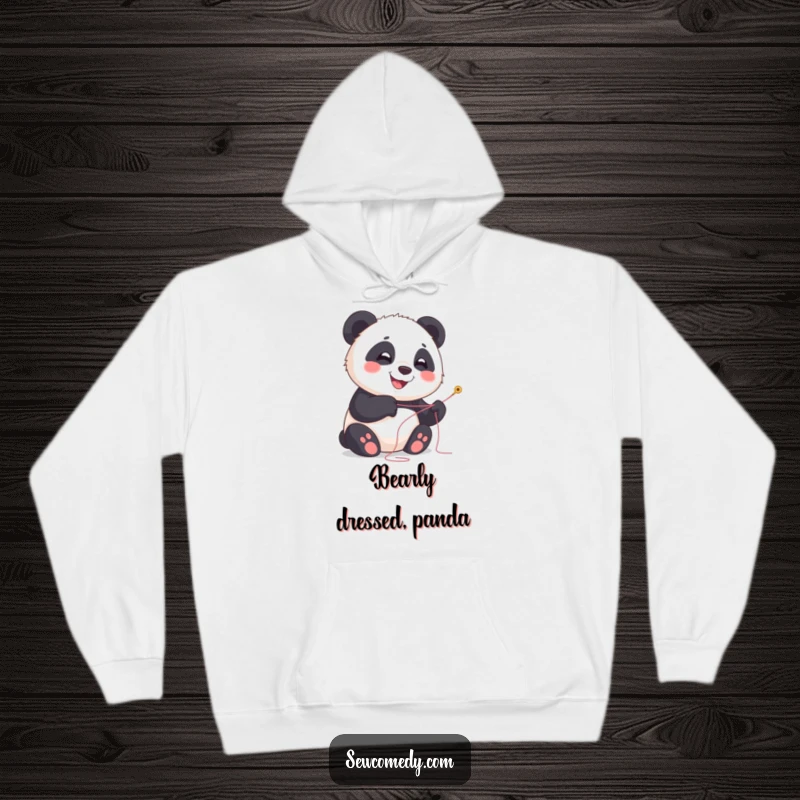 Funny panda hoodie featuring a smiling cub with needle and thread, cozy and humorous.
