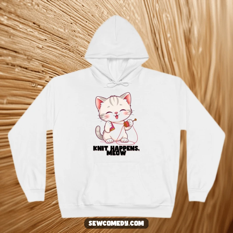 Funny kitten hoodie depicting a playful cat batting a needle and thread, perfect cozy apparel.